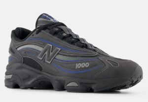 Side view of New Balance Diamond 1000 v1 sneaker in dark grey and blue with thick sole and breathable mesh upper